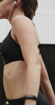 Fitness, music and stretching with woman in city for streaming service, health podcast and cardio. Wellness, exercise playlist and earphones with person outdoor for runner, warm up and radio