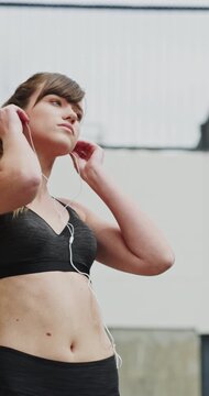 Runner, earphones and fitness with woman in city for streaming service, health podcast and cardio. Wellness, exercise playlist and training music with person outdoor for audio, workout and radio