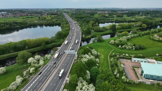 Drone aerial shot of M1 motorway crossing lakes and green landscape Wakefield