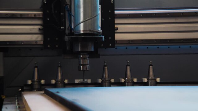 Front view of a CNC spindle above a row of tool holders inside a modern woodworking machine.