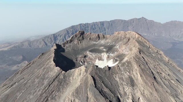 aerial close up crater rim of Pico do Fogo. Detailed view of ancient basaltic rock formations and steep geological ridges in Cabo Verde
