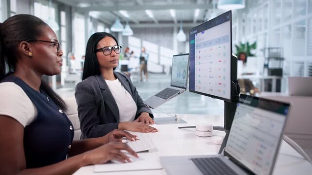 Two Women Using Laptop To Manage E-procurement