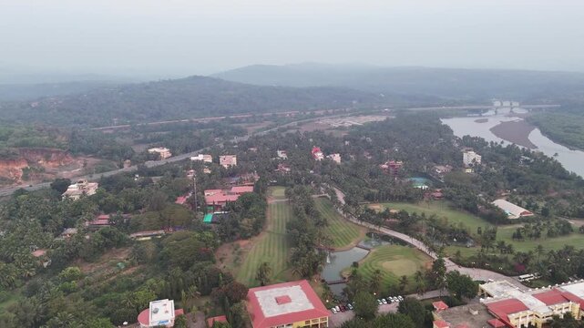 Wide cinematic aerial of a highway stretching through coastal forests and rugged landscapes, blending modern infrastructure with tropical scenery, distant beaches, and mist-covered hills.