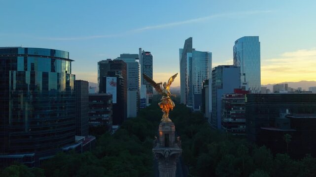 &Aacute;ngel de la Independencia al amanecer con skyline moderno de Ciudad de M&eacute;xico, toma a&eacute;rea con dron