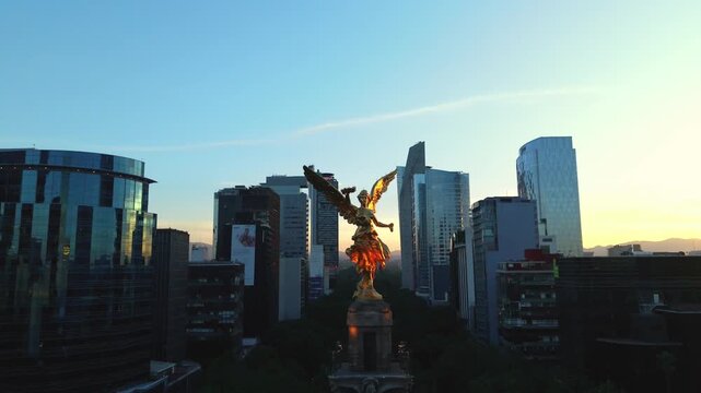 &Aacute;ngel de la Independencia al amanecer con skyline moderno de Ciudad de M&eacute;xico, toma a&eacute;rea con dron