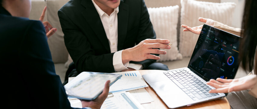 Corporate Team Presenting and Analyzing Complex Data Dashboard on a Laptop During a Strategic Business Meeting