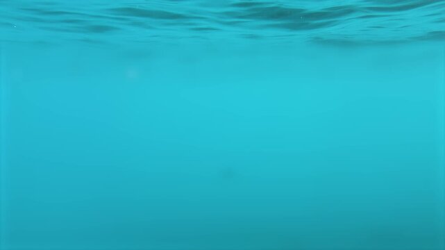 Tranquil Blue Underwater Background with Rippling Surface and Sun Rays