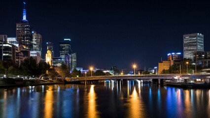 Naklejka premium A nighttime cityscape glows with lights reflecting on the river, captured in a long exposure effect.