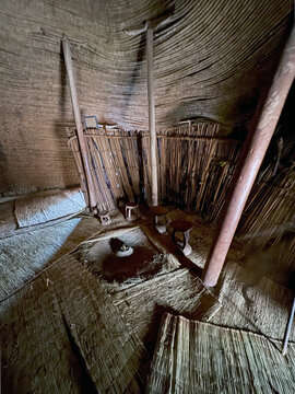Interior of a Traditional African Thatch Hut with Bamboo Walls and Grass Mats