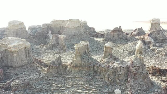 Aerial view of the unique salt formations and rocky pillars in the Danakil Desert under bright sunlight in Dalol, Afar, Ethiopia.