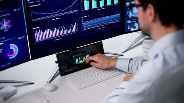 Man Studies Financial Data On Computer Monitor