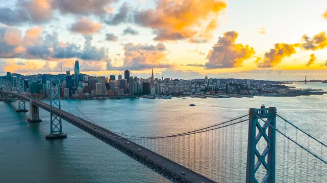 San Francisco Bay Bridge traffic with city skyline view, sunset drone hyperlapse