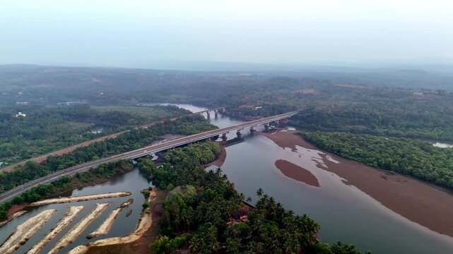 Drone footage captures the Talpona River and bridge winding through lush green landscapes, where calm waterways, tidal formations, and distant bridges create layered natural scenery.