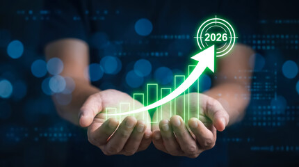 Naklejka premium Businessman holding digital hologram of increasing growth chart with arrow pointing to 2026 for financial success