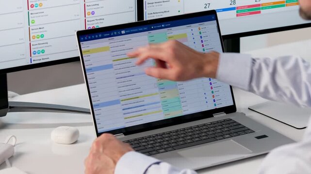 Man Uses Laptop In Office To Organize Calendar