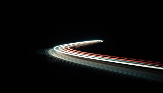 Abstract light trails of car headlights and taillights curving through darkness at night