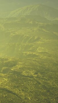 A wide landscape stretches across the scene. The ground shows rough texture with green tones. Clouds above hint at the time being evening or late afternoon.