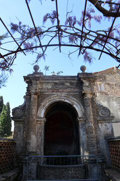 Antica fontana a ninfeo in pietra e tufo con arco monumentale ed elementi barocchi nei giardini storici di Villa d&rsquo;Este a Tivoli, Italia