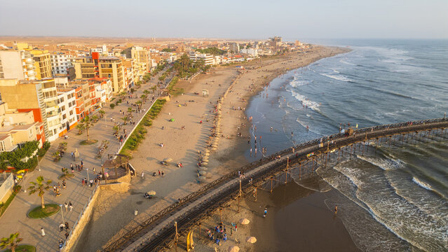 Golden sunset view of Pimentel Beach near Chiclayo on the northern coast of Peru. The image captures the warm evening light reflecting over the Pacific Ocean, creating a scenic coastal landscape with 