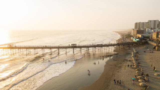 Golden sunset view of Pimentel Beach near Chiclayo on the northern coast of Peru. The image captures the warm evening light reflecting over the Pacific Ocean, creating a scenic coastal landscape with 
