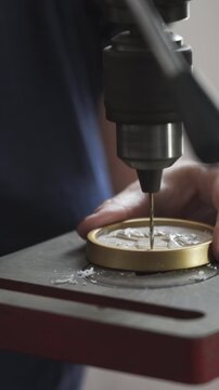 Artisan drilling hole in medallion with bench drill press