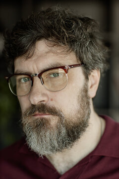 Portrait of middle aged Caucasian man wearing eyeglasses, looking at camera with serious expression, conveying confidence and professionalism
