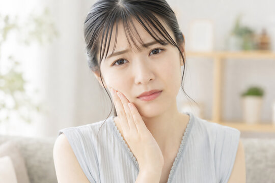 虫歯で頬を押さえて痛がる女性 Generative AI