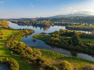 Fototapeta premium Aerial view of the winding Waikato River, New Zealand, on a beautiful autumn day. The mountain on the horizon is Maungatautari, a nature reserve
