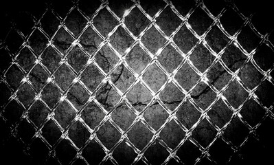 Fototapeta premium Close-up of a distressed, textured concrete wall behind a shining chain-link fence