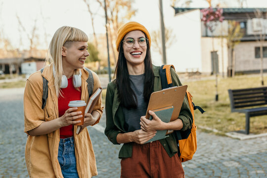 Cheerful students walking on university campus together