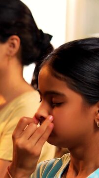 Indian young family doing meditation pranayama at home practicing breathing exercise together indoors during peaceful morning hours in a modern lavish living room promoting yoga health wellness