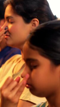 Indian young family doing meditation pranayama at home practicing breathing exercise together indoors during peaceful morning hours in a modern lavish living room promoting yoga health wellness