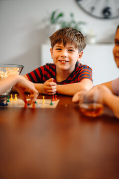 Happy kid playing board game at home