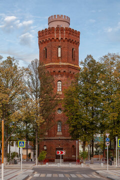 Red brick tower stands tall under blue sky