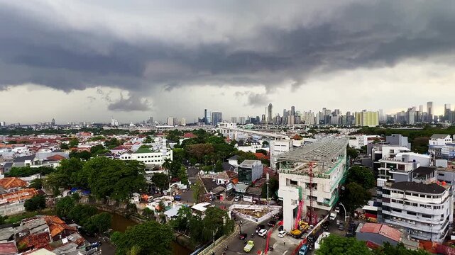 Dark clouds gather over urban sprawl. Lone lightning bolt strikes the sky. Cityscape blends low-rise homes with towering skyscrapers. Rain threatens to fall as thunder rumbles