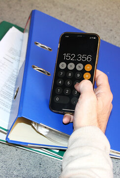 Calculadora m&oacute;vil y resultado de contabilidad y facturaci&oacute;n aut&oacute;nomo y carpeta de documentos financieros, facturas y clasificador anilla