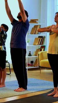 Indian family doing suryanamaskara at home practicing sun salutation yoga together indoors for healthy body and calm mind during morning routine inside a modern lavish living space
