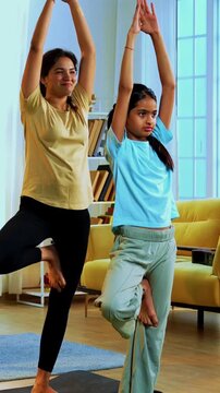 Indian family doing parvatasana yoga at home practicing mountain pose together indoors for healthy body and calm mind during morning routine inside a modern lavish living space