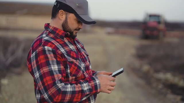 Farmer using smartphone in farmland, modern technology in agribusiness. Agribusiness and agriculture in ecological region, internet addiction and mobile gadget overuse of modern people in countryside