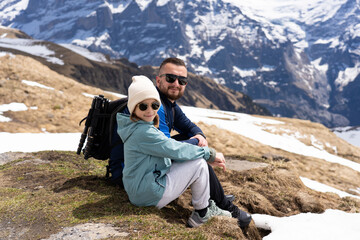 Fototapeta premium men with daughter hiking in the Swiss Alps mountains during vacation, Grindelwald, First Cliff Walk