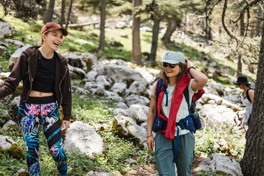 Two young caucasian women hiking in a forest, summer weather