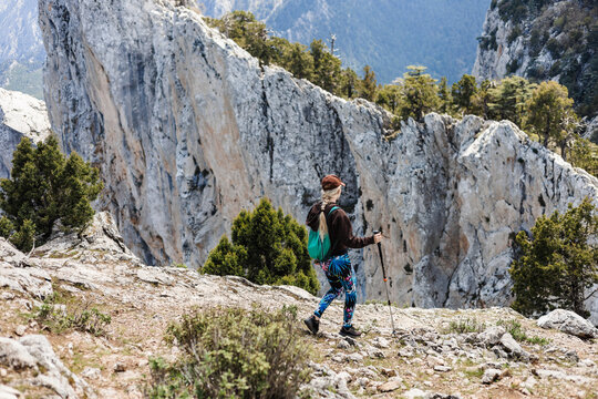 Woman  hiking on rocky mountain trail with scenic view