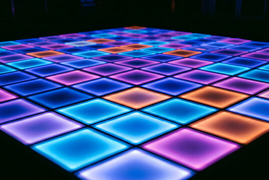 Grid of colorful glowing square lights on dance floor in dark night location.
