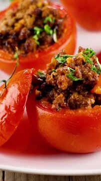 Traditional french stuffed tomatoes with minced meat and fresh herbs, baked tomatoes farcies on white plate