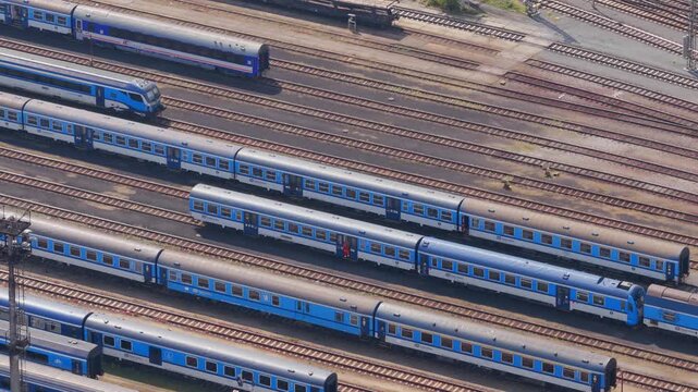 Aerial view of multiple blue passenger trains parked on parallel tracks at a railway depot in Prague, Prague, Czechia.