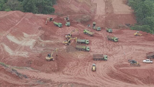 Aerial view of loading and unloading activities of trucks and excavators for highway construction
