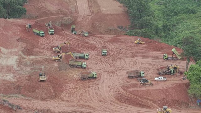 Aerial view of loading and unloading activities of trucks and excavators for highway construction