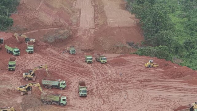 Aerial view of loading and unloading activities of trucks and excavators for highway construction