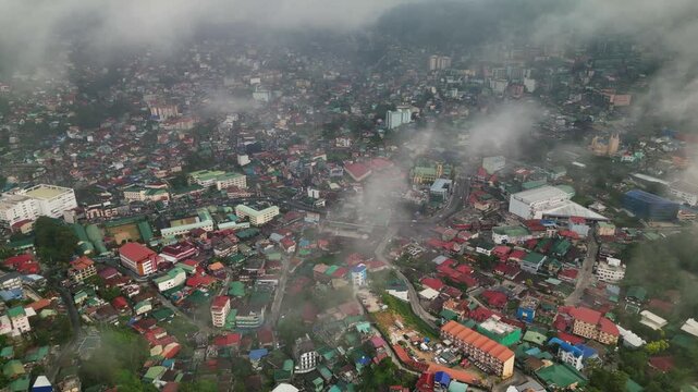 Panoramic aerial view of Baguio City in Benguet, Philippines with urban landscape and low clouds covering the mountain city