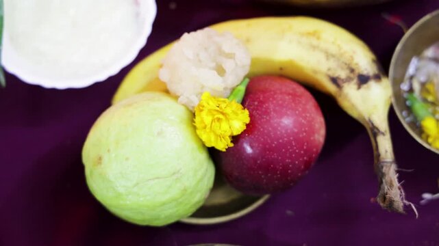 traditional hindu puja offerings with banana apple guava and sacred sweets during religious ceremony